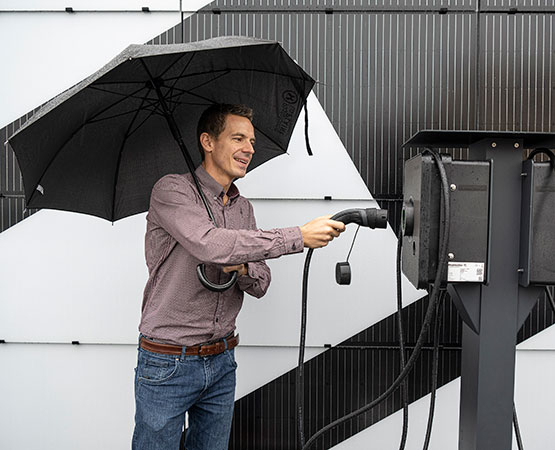 Patron d’Electro-Sol, Kilian Thonney pose devant la façade solaire apposée sur les murs de l’entreprise, à Cossonay-Ville, où se rechargent les véhicules de la firme. ARC Jean-Bernard Sieber